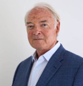 A man with white hair and wearing a blue suit.